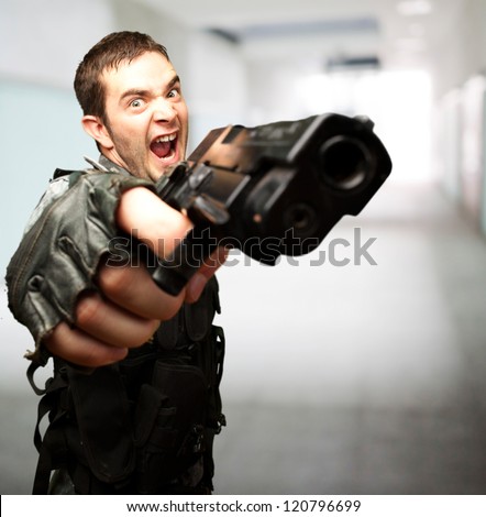 Angry Soldier Holding Gun against an abstract background