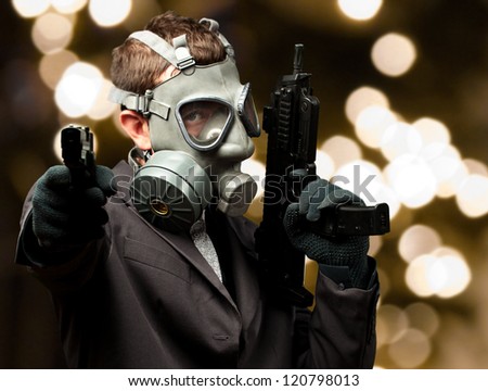 Businessman Holding Gun With Gas Mask against a background of gold lights