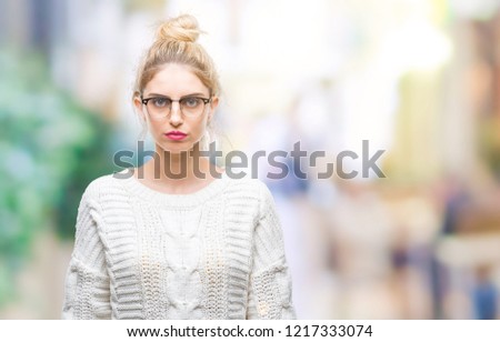 Young beautiful blonde woman wearing glasses over isolated background with serious expression on face. Simple and natural looking at the camera.