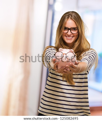 Young Woman Holding Piggy bank Wearing Glasses, indoor