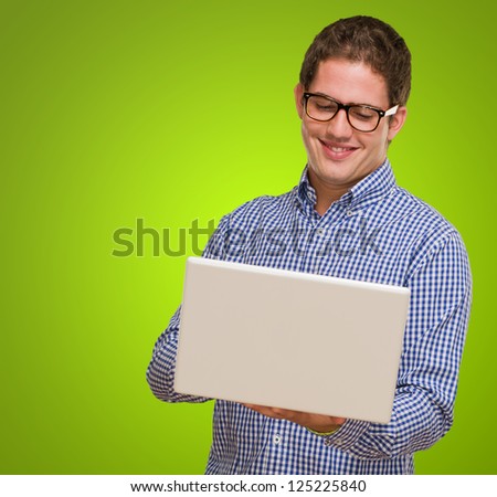 Happy Young Man Using Laptop against a green background