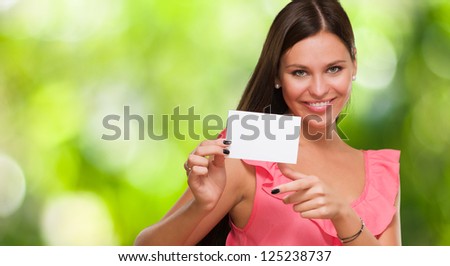 Portrait Of A Young Woman Holding Blank Card against a nature background