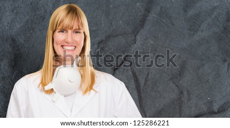 Female Doctor With Protective Mask Around Neck against a grunge wall background