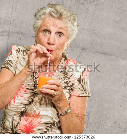 Woman Sipping Juice Through Straw On Wall