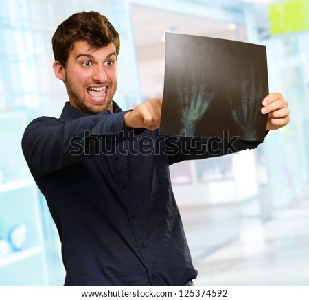 Young Man Holding X Ray Report Gesturing, Indoors - stock photo