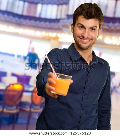 Young Man Holding Glass Of Orange Juice, Indoors