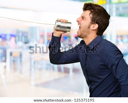 Man Shouting In Tin Can Telephone, Indoors