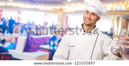 Male Chef Holding Wooden Spoons Gesturing, Indoors