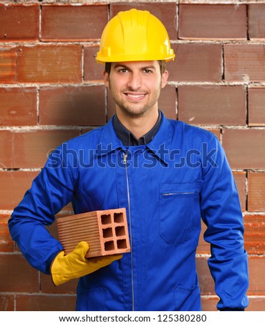 Happy Engineer Holding Brick, Indoors