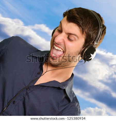 Portrait Of Young Man Listening Music, Outdoors - stock photo