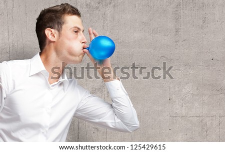 Portrait Of Young Man Blowing A Balloon, Indoor