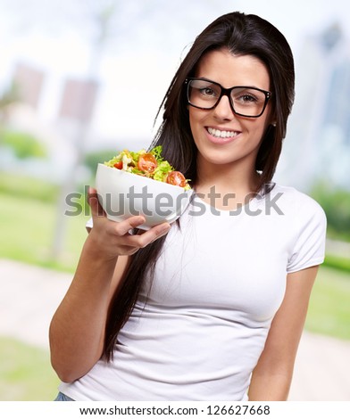 Young Girl Showing A Bowl Of Salad, Outdoor