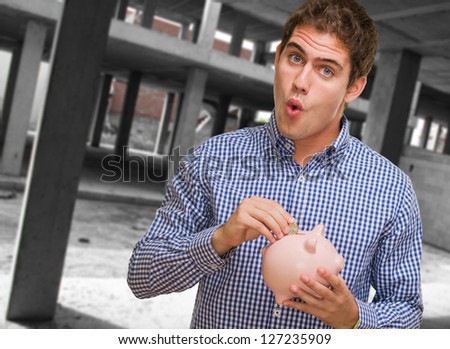 Young Man Holding Piggy Bank, indoor