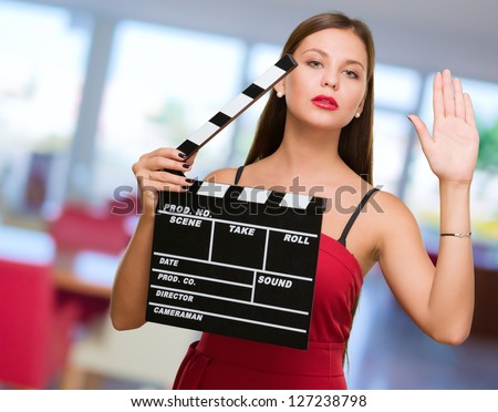Young Woman Holding Clapper Board, indoor