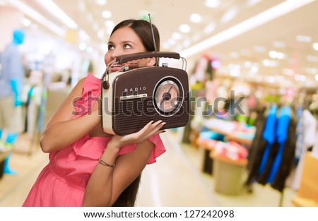 Portrait Of Happy Woman Holding Radio at a mall