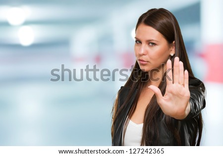 Young Woman Showing Stop Hand Gesture in a garage