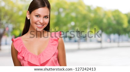 Portrait Of Happy Woman In Pink Dress against a street background