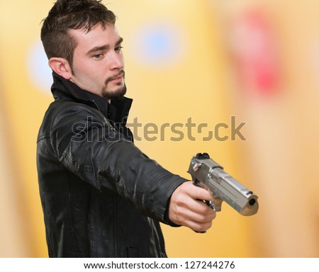 Portrait Of A Man Holding Gun against an abstract background