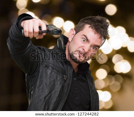furious man pointing with a gun against an abstract light background