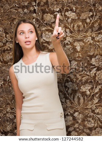 Portrait Of A Young Woman Pointing Up against a vintage background