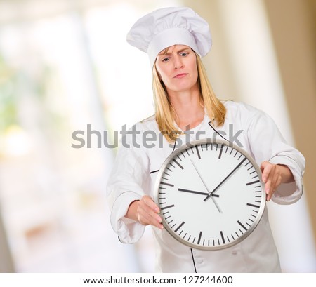 Female Chef Holding Clock against an abstract background