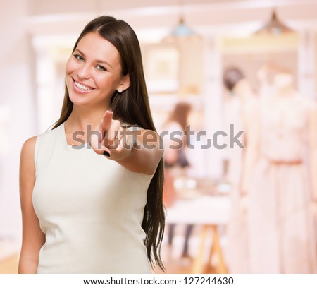 Portrait Of A Happy Young Woman Pointing At You in a shop