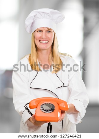 Female Chef Holding Telephone against an abstract background