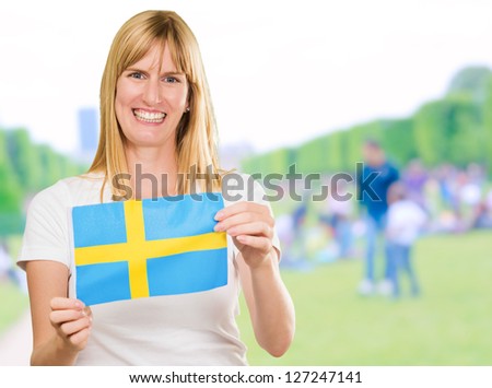 Happy Woman Holding Swedish Flag at a park, outdoor