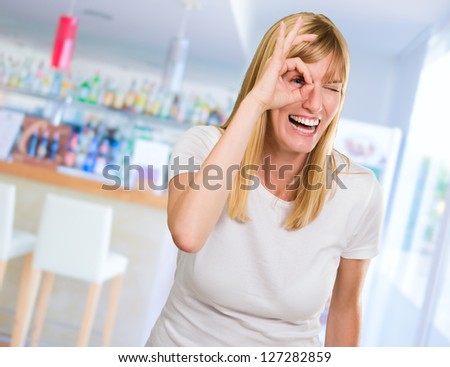 Happy Woman Looking Through Finger at a bar