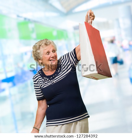 Happy Mature Woman Holding Shopping Bag, Indoors