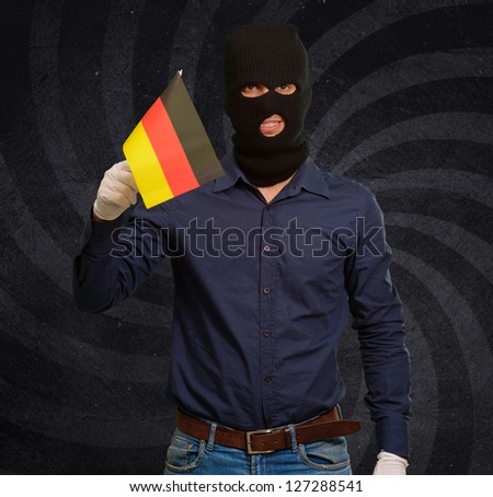 Man wearing robber mask and holding flag, indoor