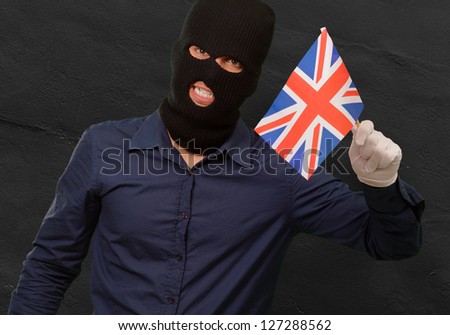 Portrait of a man wearing mask holding a flag isolated on black background