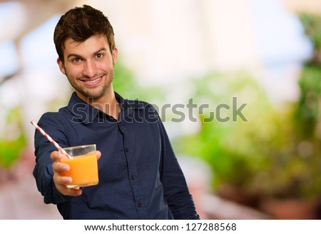 Young Man Holding Glass Of Orange Juice, Outdoors
