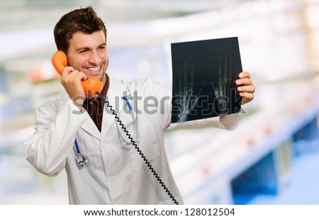 Happy Doctor Holding X-ray And Telephone, Indoors
