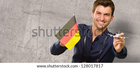Photographer Holding German Flag And Miniature Airplane, Indoor