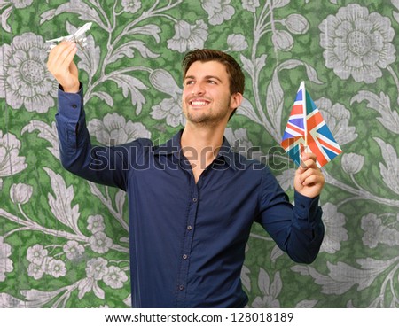 Man holding flag and miniature of airplane, wallpaper