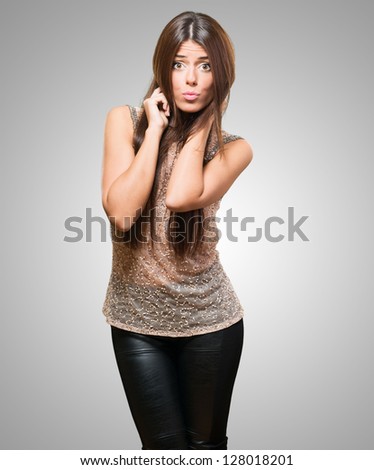 Young Woman Doing A Scared Face against a grey background