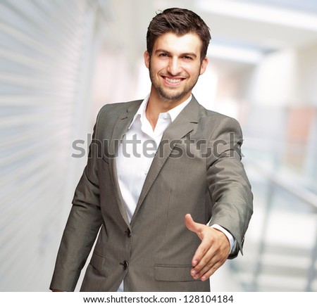 Portrait Of  Young Businessman In A Suit Holds Out His Hand For A Handshake, Indoor