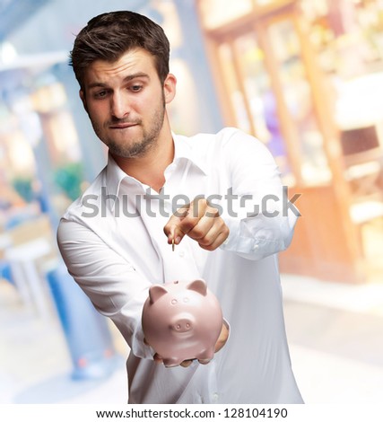 A Businessman Putting A Coin Into A Pink Piggy Bank, Indoor