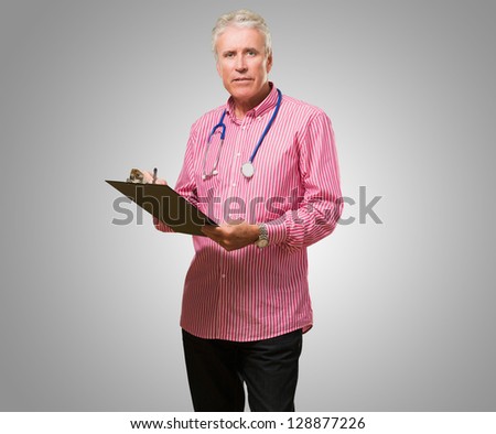 Male Doctor Holding Writing Pad against a grey background