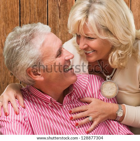 Portrait Of Happy Couple Looking At Each Other against a wooden background