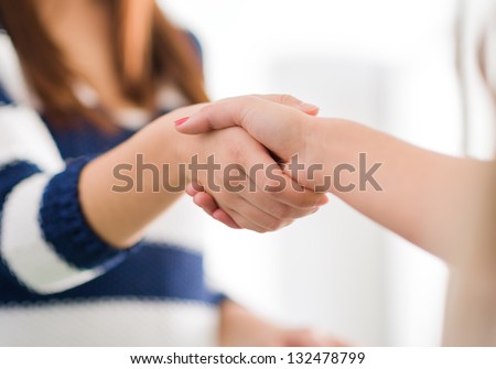Close Up Of Two Women Shaking Hands, Indoors