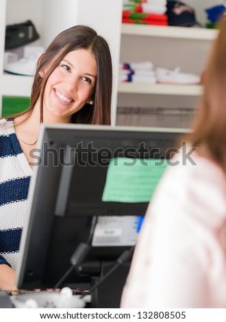 Happy Female Cashier At Counter In Supermarket