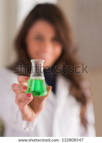 Portrait Of Female Scientist Holding Chemical, Indoors
