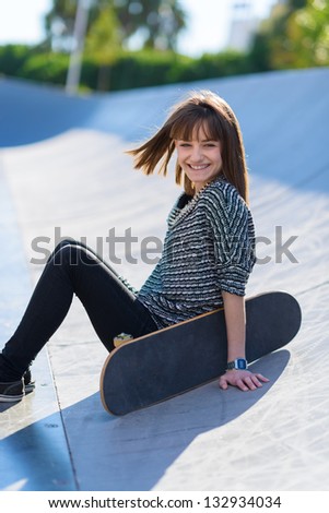 Portrait Of Happy Woman Sitting With Skateboard, Outdoors