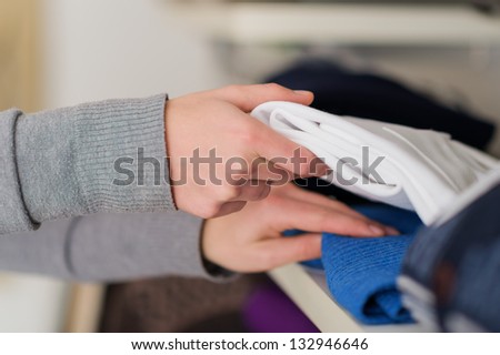Close-up Of Female Hand Picking Shirt, Indoors