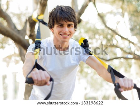 Young Man Exercising With Stretch Band; Outdoors