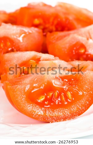 fresh tomato pieces on a plate on white background