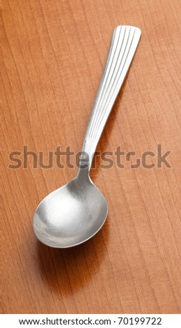 metal spoon on a wooden surface, closeup