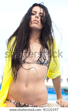 young pretty woman wearing bikini with wet air at pool
